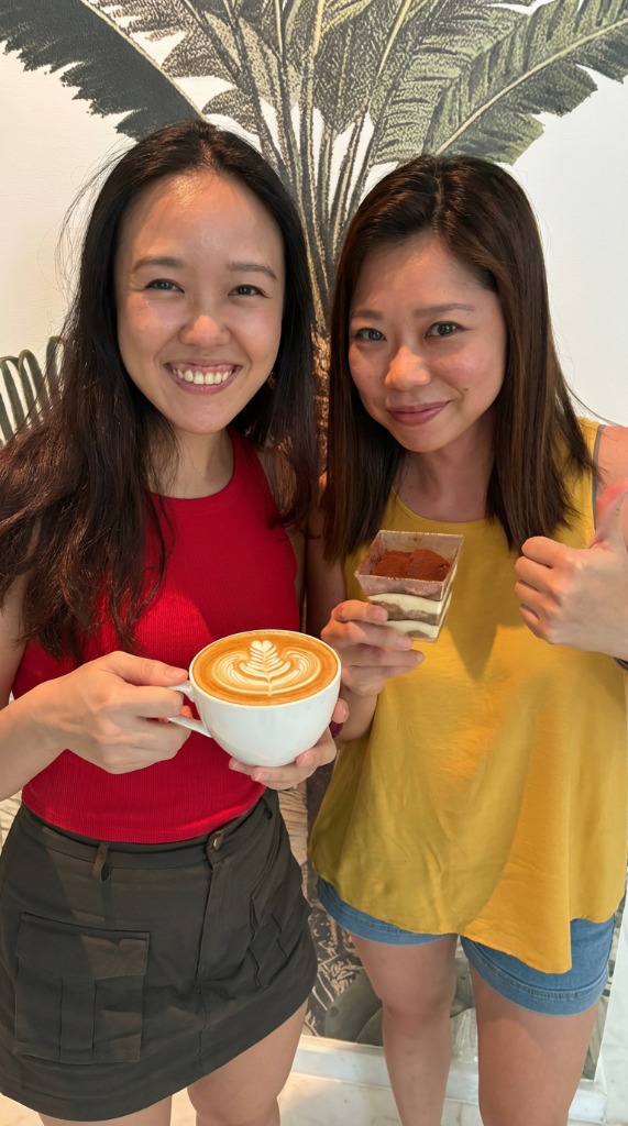 Smiling friends with lattes and tiramisu
